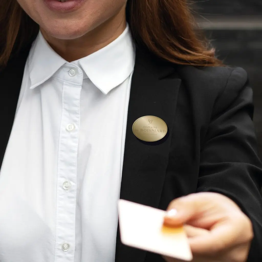 Broche magnétique dorée portée sur la veste d'un membre du personnel