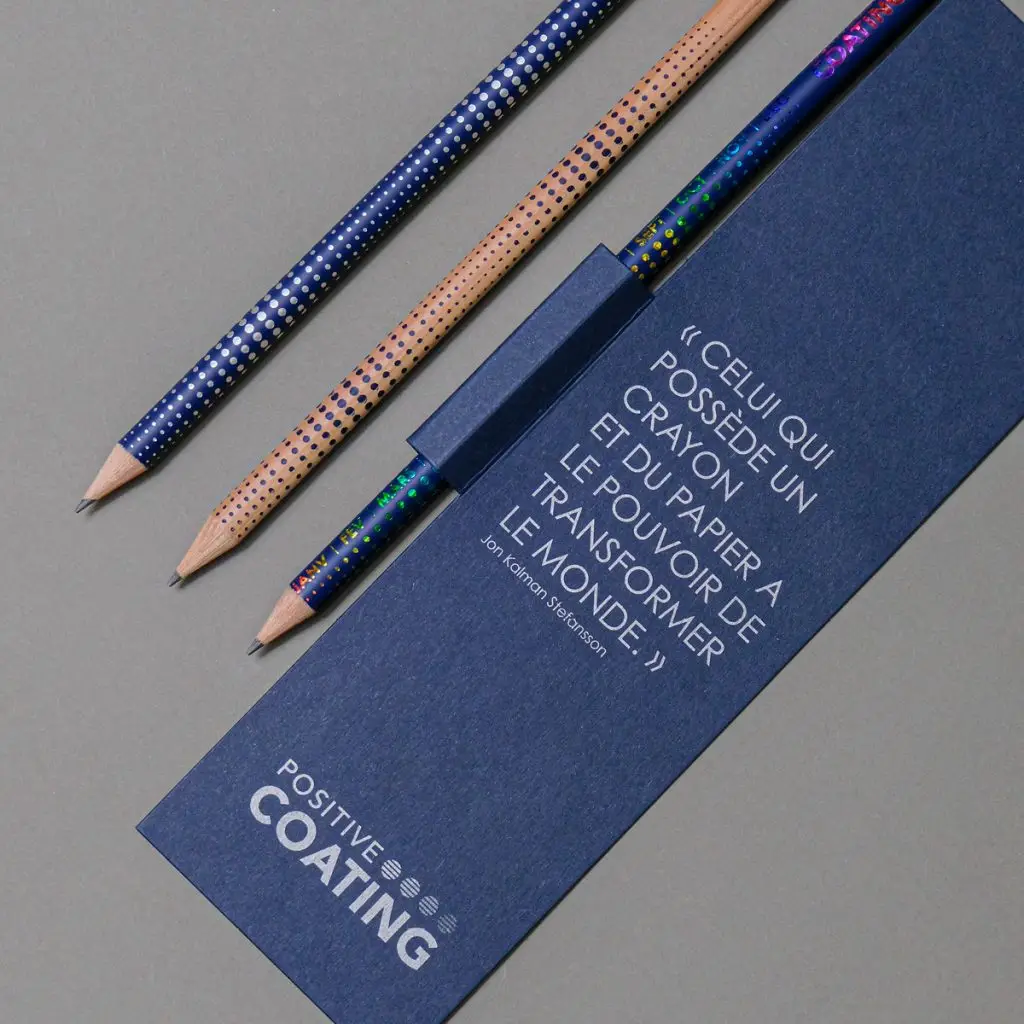 Carte de vœux bleue Positive Coating et crayons aux couleurs arc-en-ciel de son procédé
