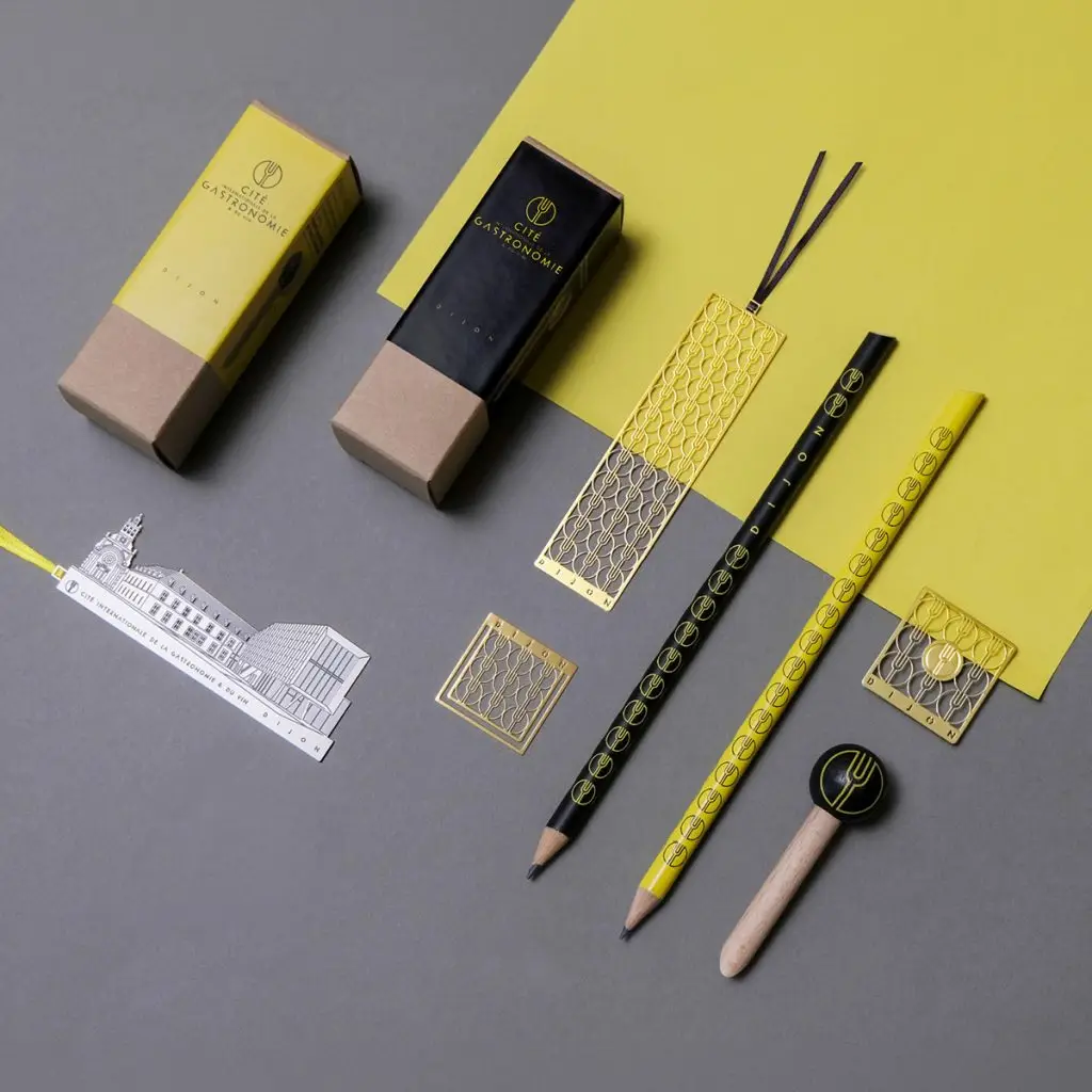 Gamme d'objets créée pour la Cité internationale de la gastronomie et du vin : marque-pages, magnet, crayons et règle aux couleurs jaune et noir de la Cité
